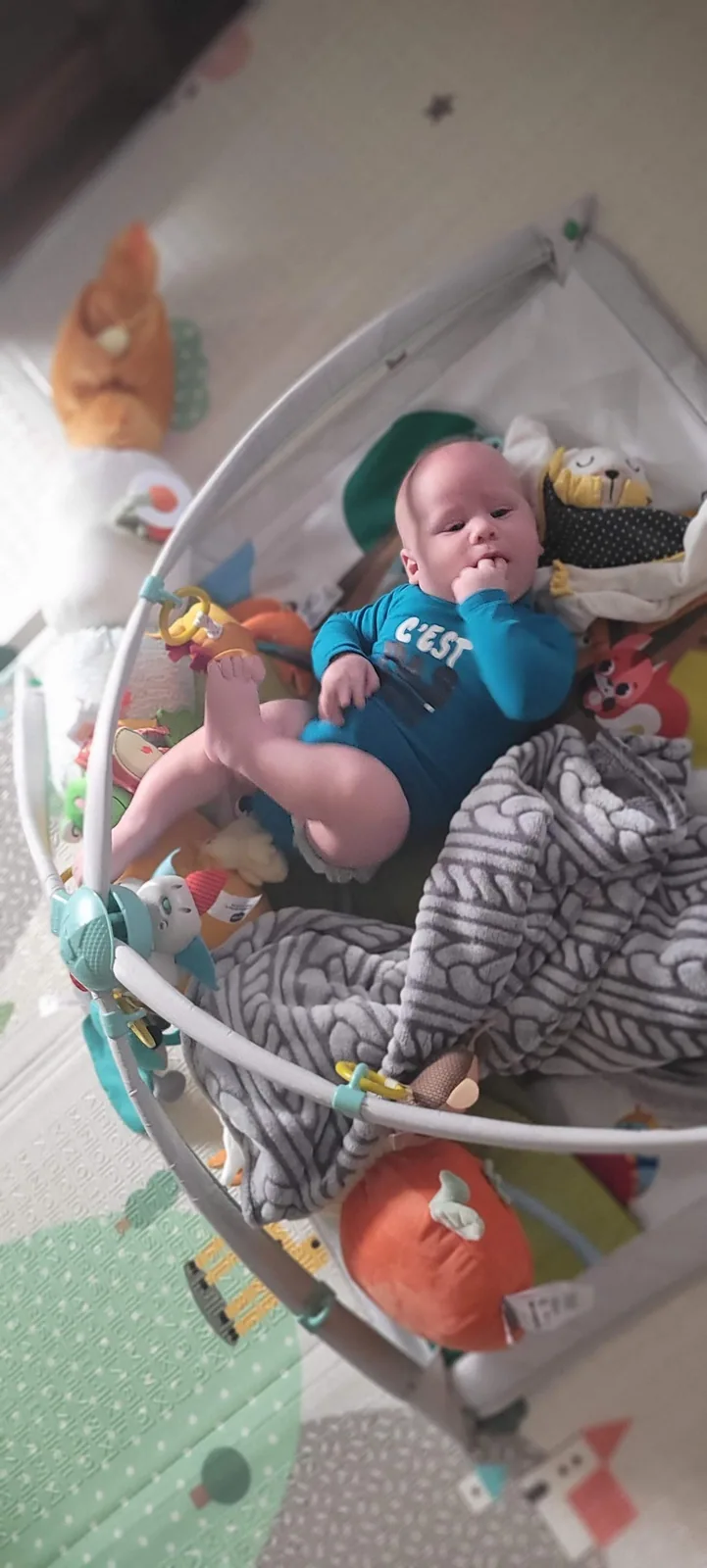 Bebe explorant sur un tapis d'eveil ferme
